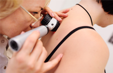 [Translate to French:] Physician looking on skin of patient with an miscroscope instrument